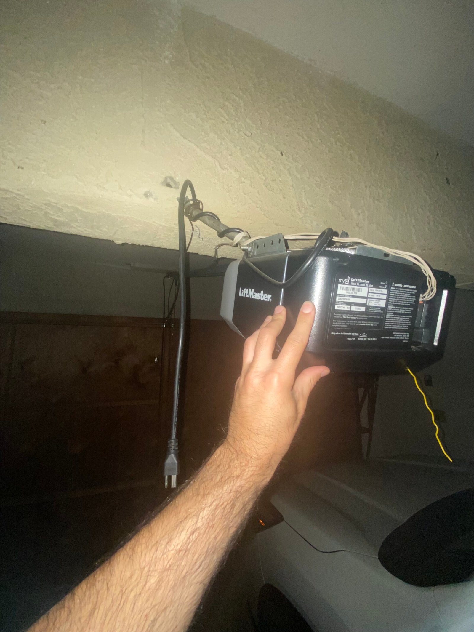 Technician inspecting a Pasadena garage door opener that stops or reverses while closing